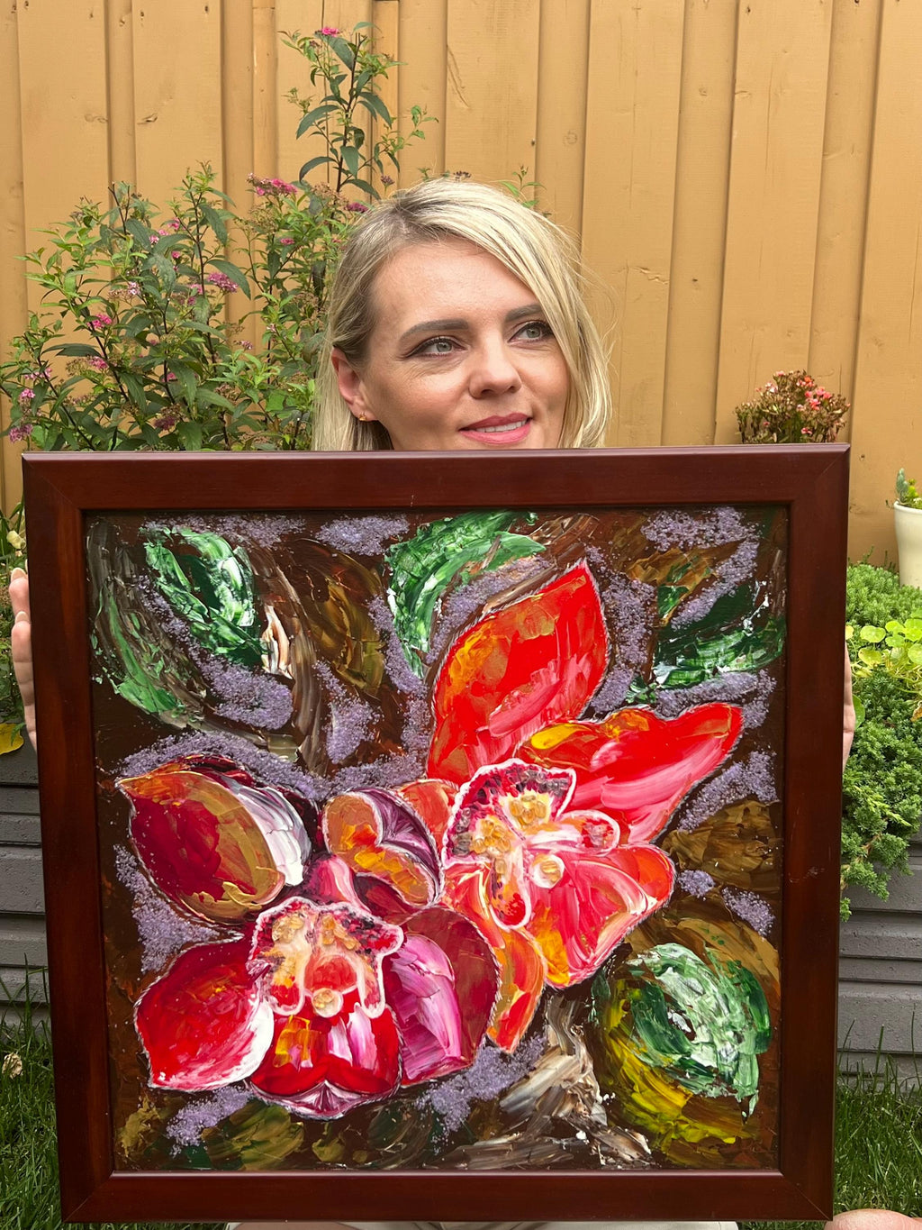 Artist holding Red Orchid, an original acrylic painting
