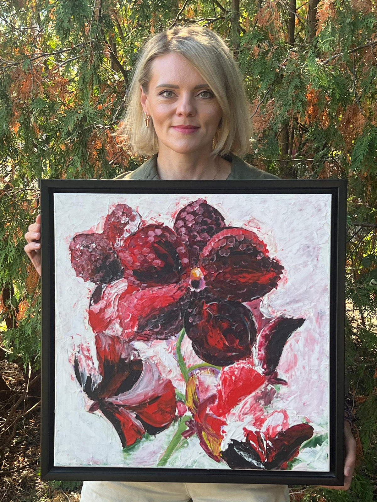 Artist holding Red Orchid, an original acrylic painting