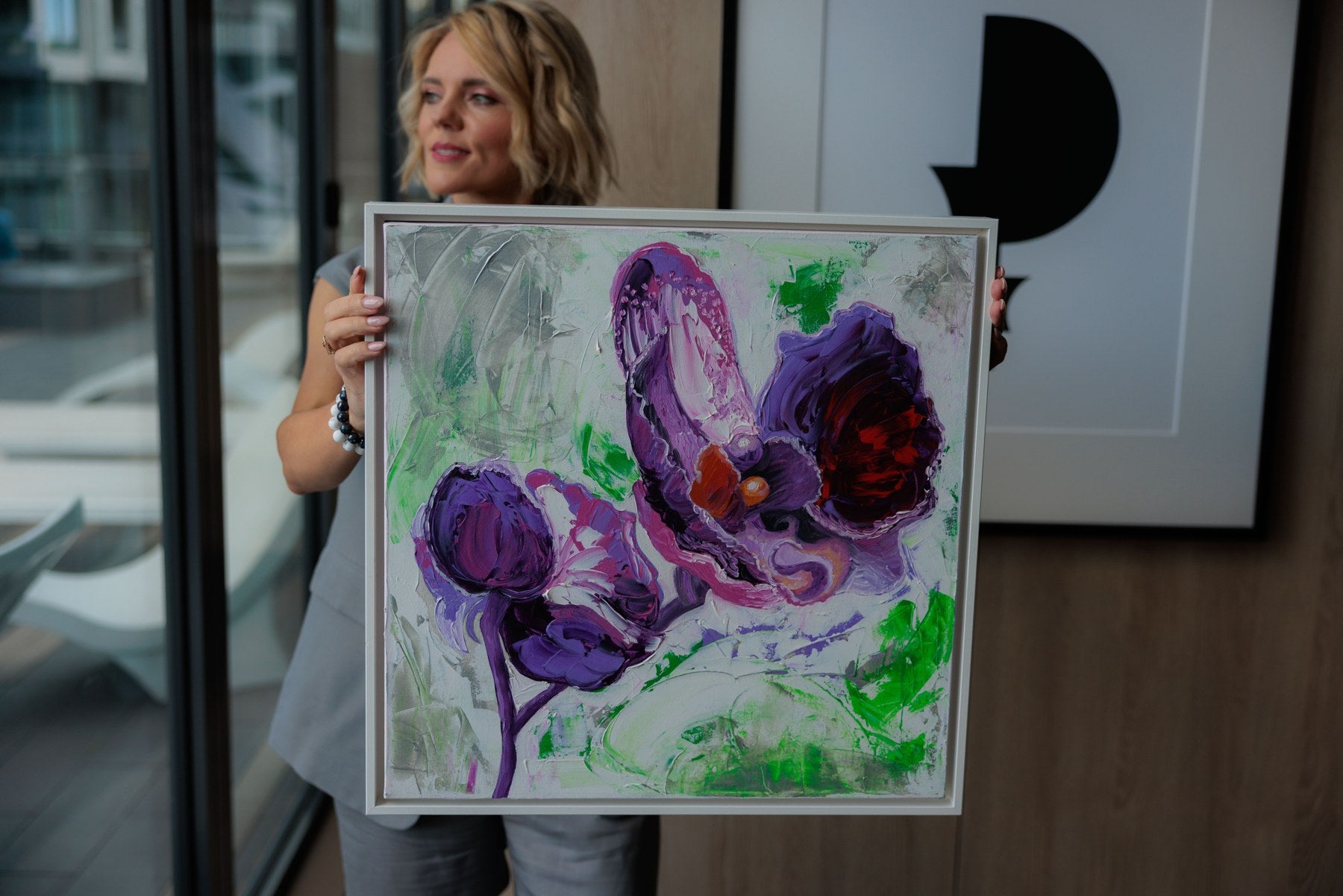 Veronika Melnyk holding her original purple orchid painting